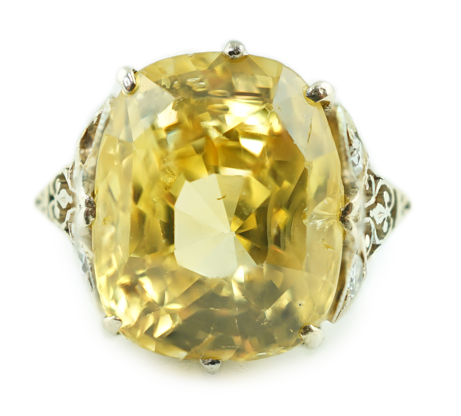 A mid 20th century platinum? and single stone fancy cushion cut yellow sapphire set dress ring with six stone diamond set pierced mount